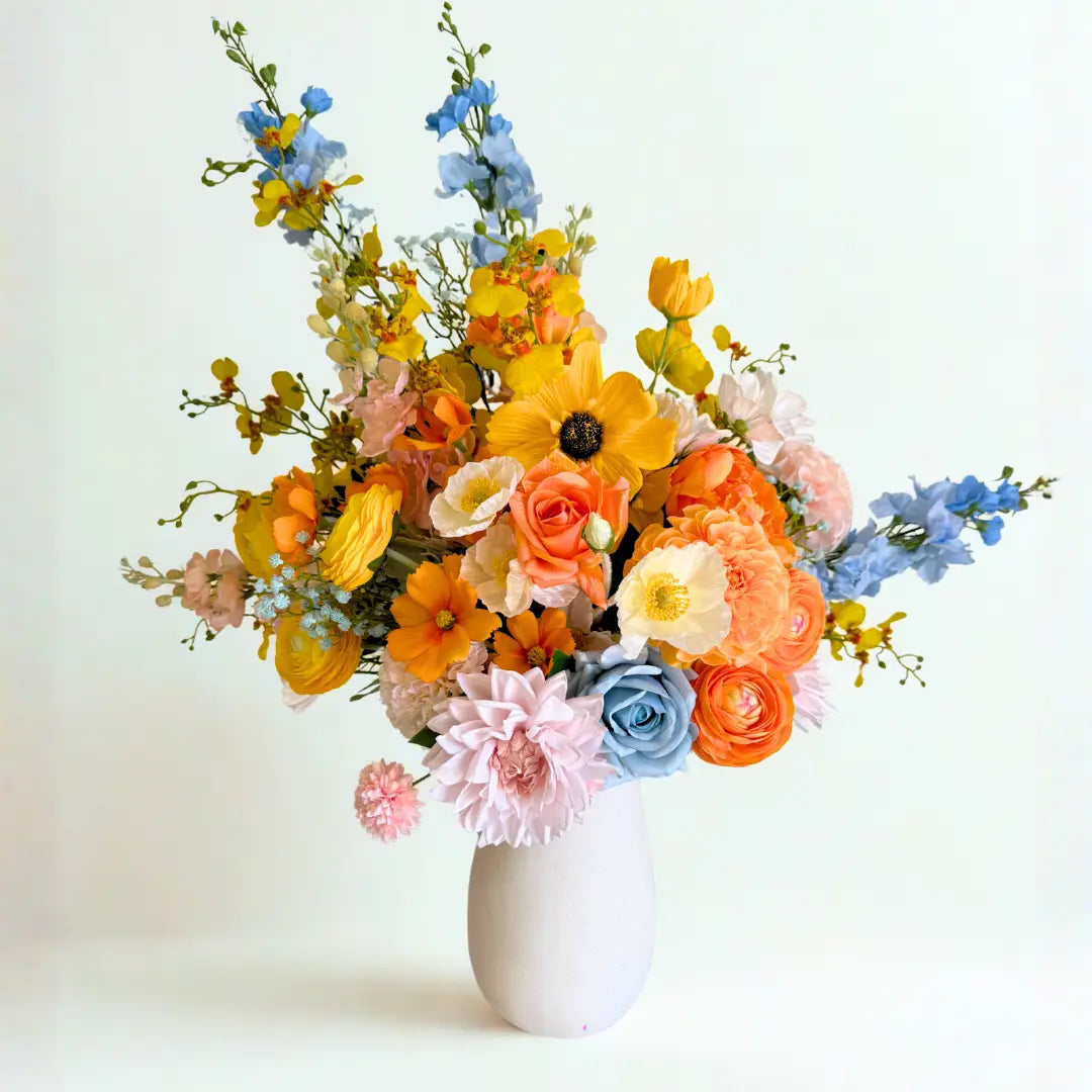 Bouquet of colorful flowers in a white vase on a light background
