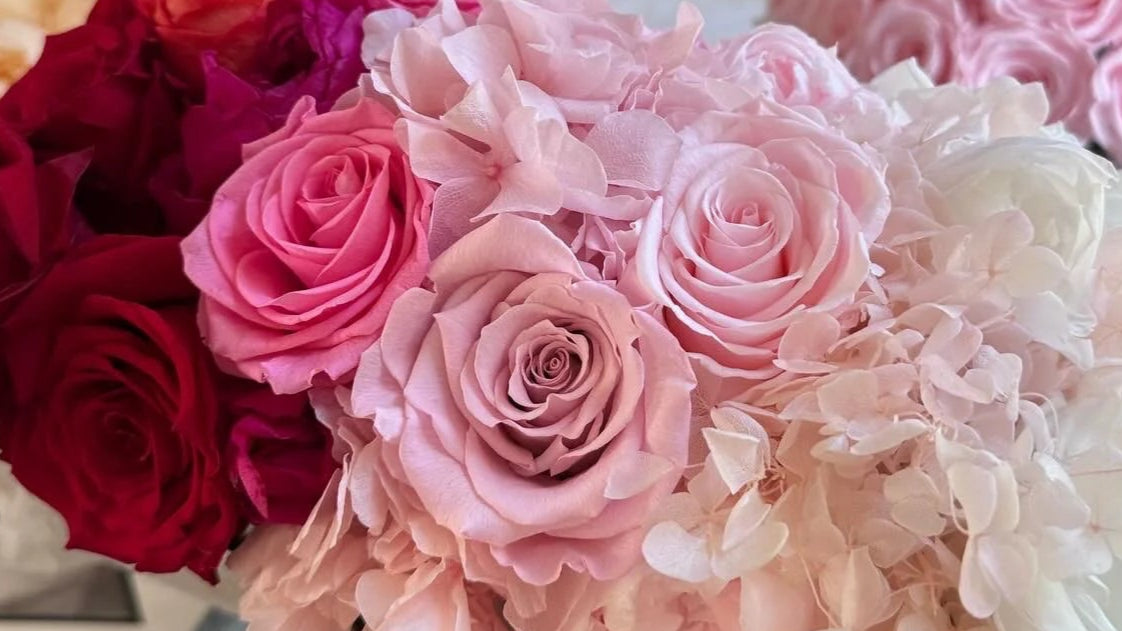 Bouquets of red, pink, and white roses on a table.
