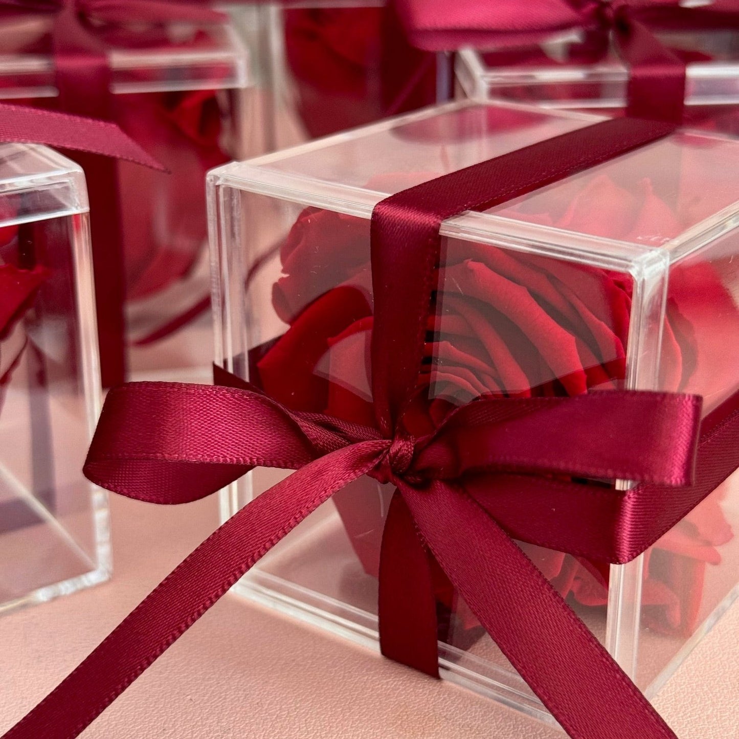 "Detailed close-up of a preserved single rose inside a clear acrylic box, showcasing its vibrant petals and timeless beauty."