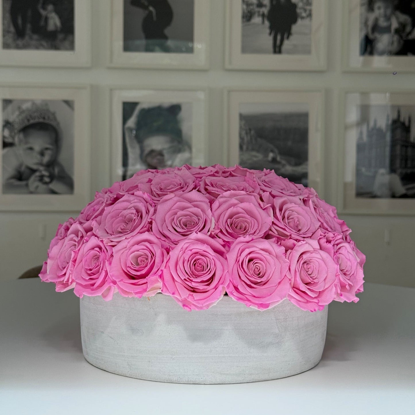 Cement pot base of everlasting roses on clean table setting.