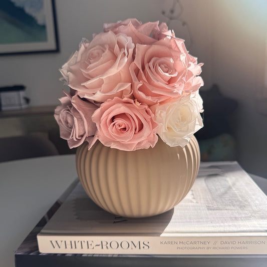 Elegant Ribbed Sand-Colored Pot featuring a beautiful arrangement of cream-colored roses.