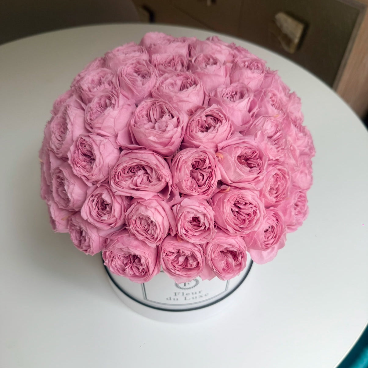 Full Arrangement View: A top-down perspective of the round box filled with preserved peonies, displaying the symmetrical and luxurious floral arrangement.