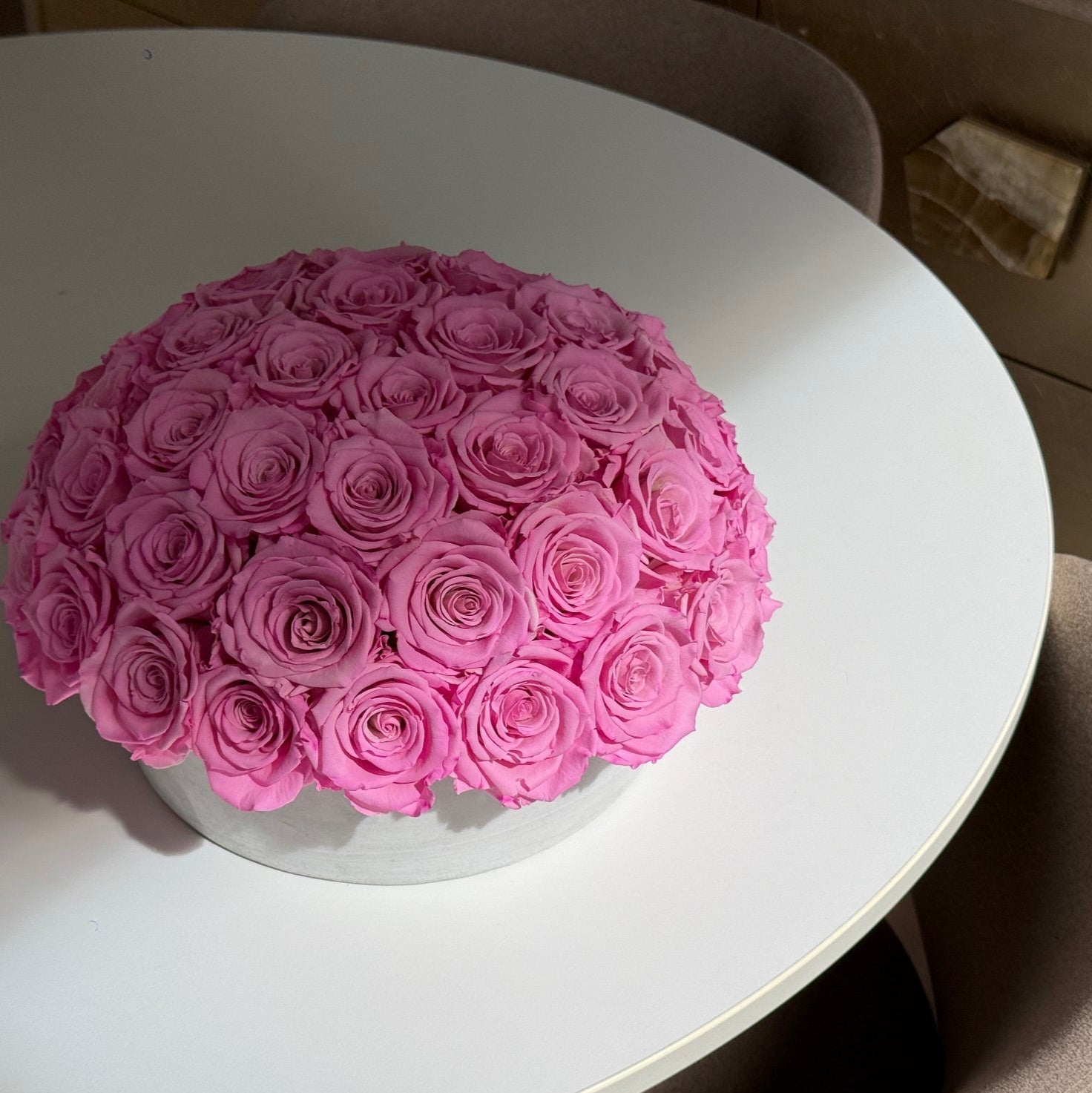 Side view of Fleur du Luxe everlasting roses in minimalist cement pot.