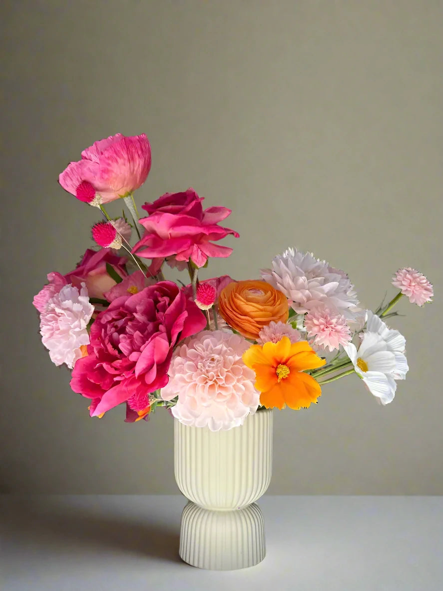 Colorful flower arrangement in a vase on a table with a blurred background